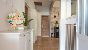 A hallway with a white cabinet, a painting, and a potted plant. - Awesome home in Kosute (Kosute)