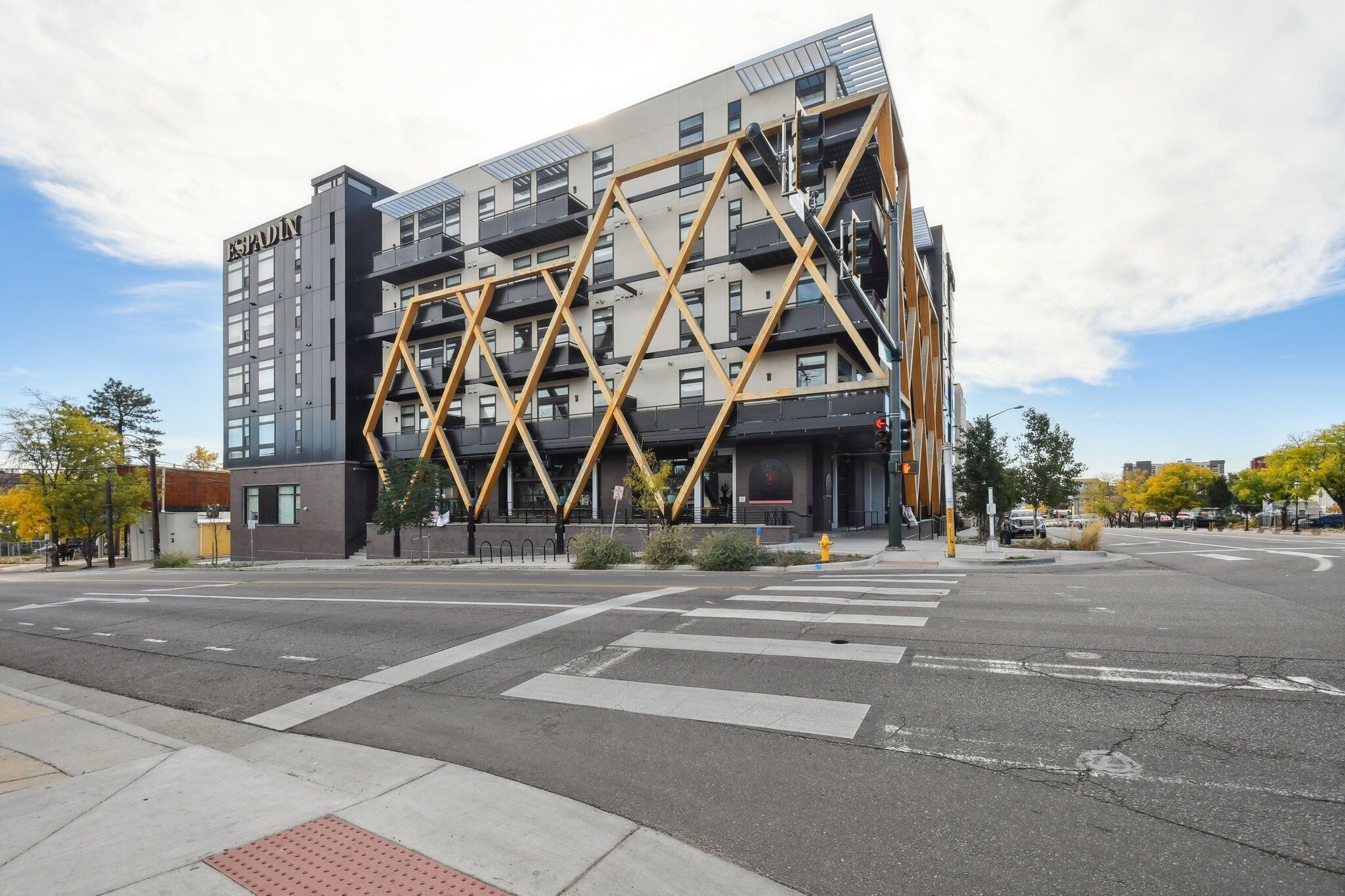 Ein modernes Gebäude mit einer markanten, geometrischen Fassade und mehreren Balkonen.