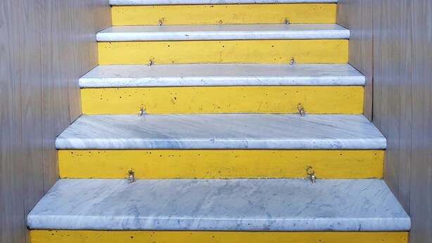 A staircase with yellow steps leading up to a landing. - Hostal al Fin del Mundo (Punta Arenas)