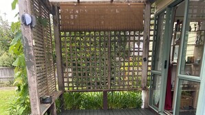 A wooden deck with a pergola and a glass door leading to a room. - Back to Basics at Iconic Wharekaho Bay (Simpsons Beach) Whitianga (Wharekaho)