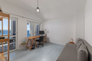 A modern room with a desk, computer, and a sofa.