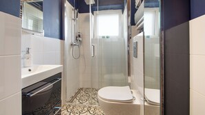 Un baño con ducha, inodoro y lavamanos.