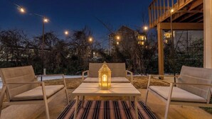 An outdoor seating area with a table and chairs, a lantern, and string lights. - Cozy Branson Studio Near Strip & SDC / Patio / Dog Friendly (Branson)