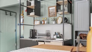 A modern kitchen with a built-in stove, a sink, and a countertop. There are shelves above the counter holding various kitchen items. - Cozy Branson Studio Near Strip & SDC / Patio / Dog Friendly (Branson)