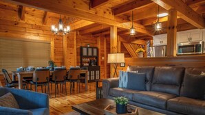 L’intérieur d’un chalet accueillant, avec un coin repas, un canapé et une table basse.