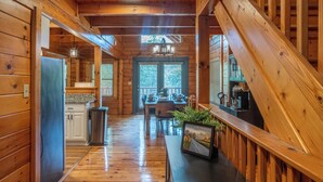 Un intérieur en bois comprenant une cuisine, un coin repas et un escalier.