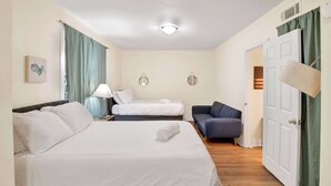 A hotel room with a large bed, a smaller bed, a sofa, a desk with a lamp, and a door. - Near Downtown and Cornerstone - Southern Sunshine (Mobile)