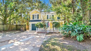 A two-story house with a front yard, a white fence, and a large plant. - Near Downtown and Cornerstone - Southern Sunshine (Mobile)