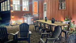 An outdoor dining area with a wooden table and chairs, a grill, and potted plants. - 10 Mi to Crane Beach: Wooded Home Near Boston! (Topsfield)
