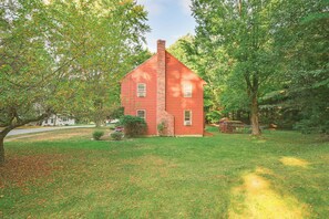 A red brick house with a chimney, surrounded by a grassy yard and trees. - 10 Mi to Crane Beach: Wooded Home Near Boston! (Topsfield)