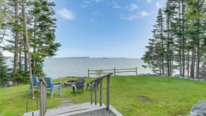 A deck with chairs overlooking a body of water, surrounded by trees. - Waterfront Roque Bluffs Hideaway w/ Private Beach (Roque Bluffs)