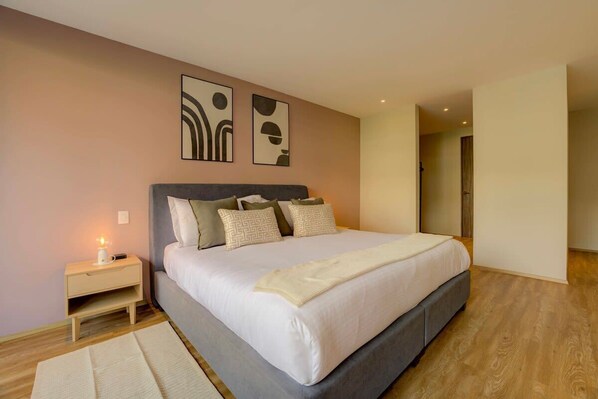 Une chambre à coucher avec un lit, une table de chevet et des œuvres d’art murales.