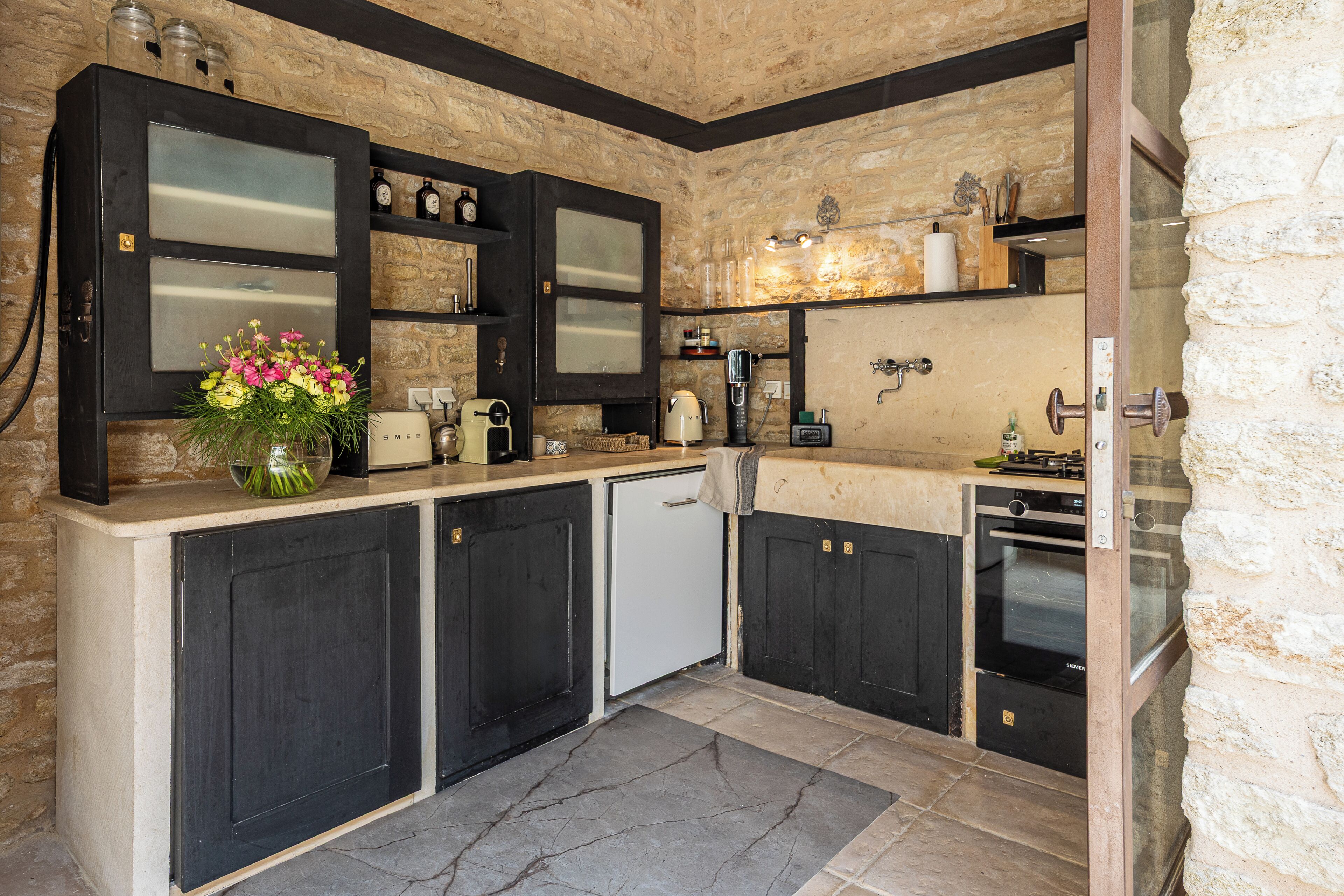 A kitchen with dark cabinets, a white refrigerator, and a built-in oven.