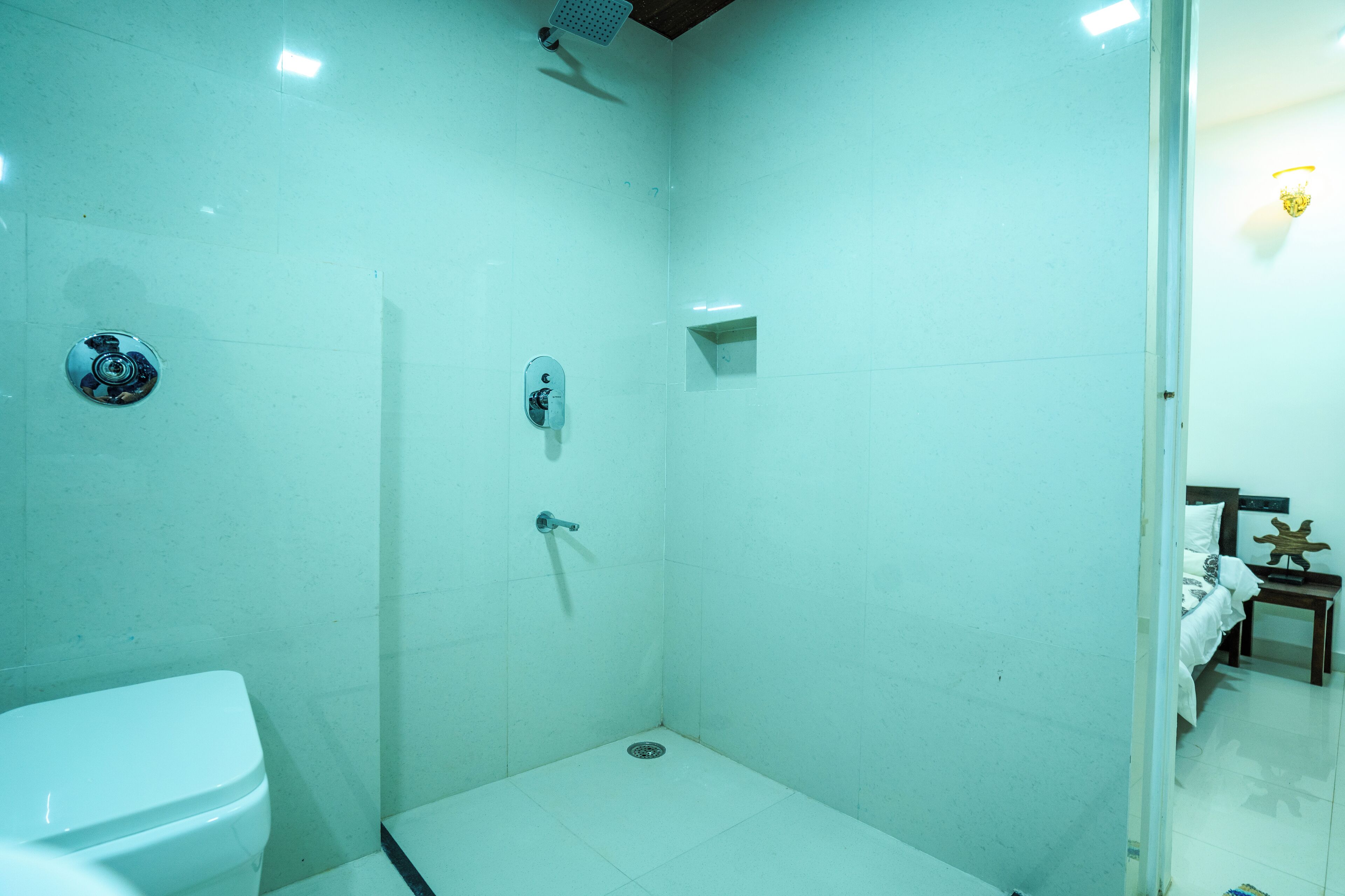 Un baño pequeño con paredes blancas, un inodoro, una ducha y un lavabo.