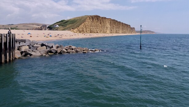 A coastal beach with rocky outcrops and a clear sky. - Strand Cottage - Burton Bradstock, Bridport (Burton Bradstock)
