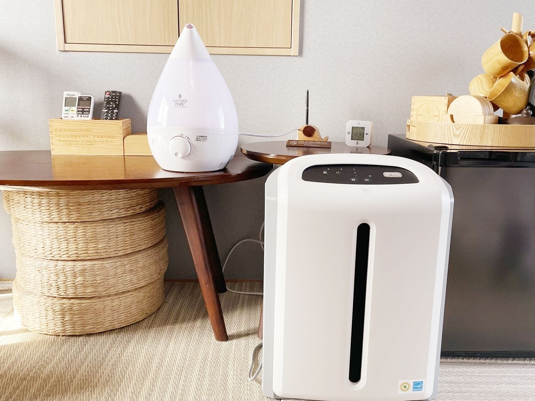 A kitchen with a white toaster, a white rice cooker, and a wooden table with a woven basket.