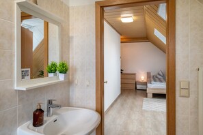 A modern bathroom with a sink, mirror, and potted plants. - Apartment 'Ferienwohnung An Der Haferkoppel' with Private Terrace and Wi-Fi (Groß Kussewitz)