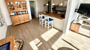 A modern kitchen with wooden cabinets, a central island, and pendant lighting.