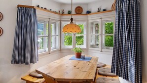 A corner room with a wooden table, a potted plant, and a hanging lamp. - Holiday Home 'Zaunkönig' with Mountain View and Private Terrace (Mittenwald)