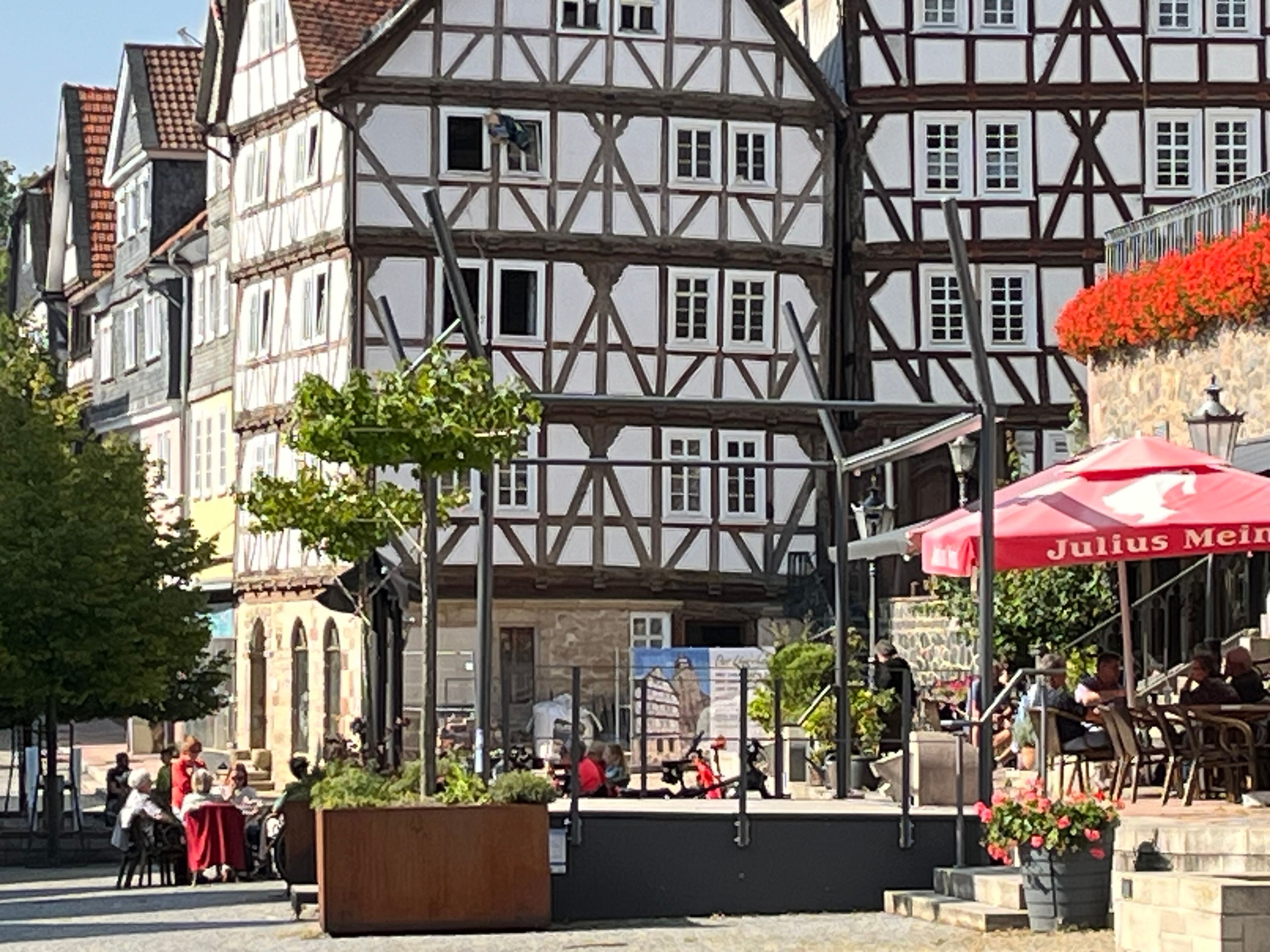 Un edificio tradicional con entramado de madera, con una cafetería y terraza.