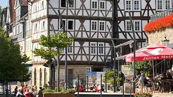 Un edificio tradicional con entramado de madera, con una cafetería y terraza.