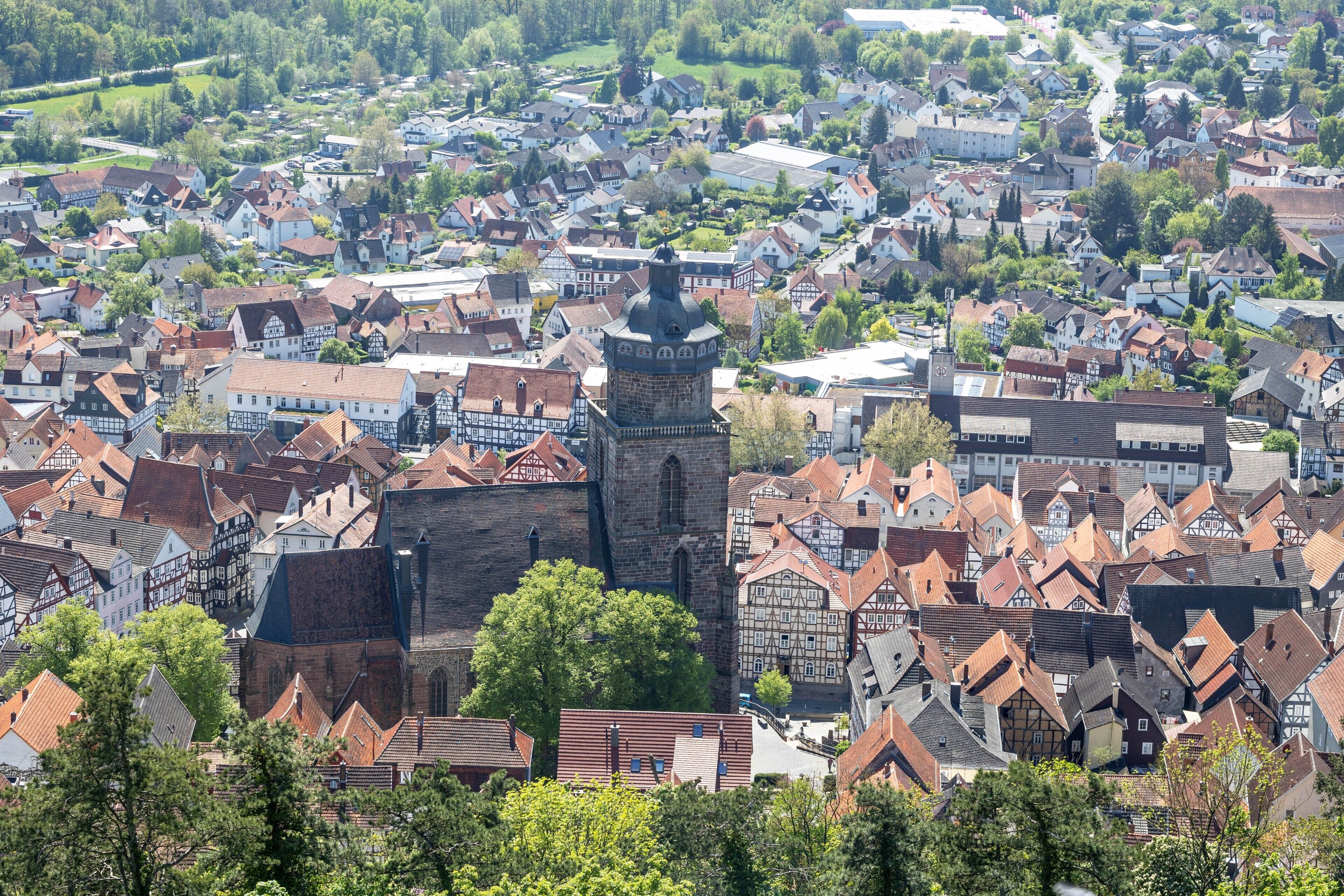 A town with historic buildings, a prominent tower, and a dense layout of houses.