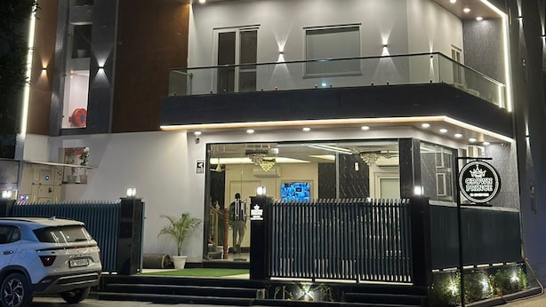 A multi-story building with a modern design, featuring balconies and a ground-level entrance with a sign for "Grown Prince." - The Crown Prince (Greater Noida)
