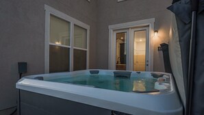 A hot tub with a view of a house through a window. - West Jordan Modern Home | Fenced Yard, New Build, Sleeps 7! (West Jordan)