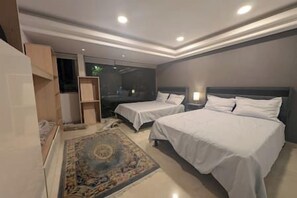 Une chambre d’hôtel avec deux lits, un grand miroir et un sol recouvert de moquette.