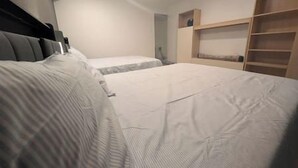 Ein Schlafzimmer mit zwei Betten, einem Kleiderschrank und einem kleinen Schreibtisch.