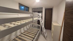 Ein Etagenbett in einer Diele mit Tür und Fenster.