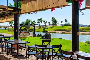 Guests can dine al fresco with a view of the serene lake and lush palm trees.