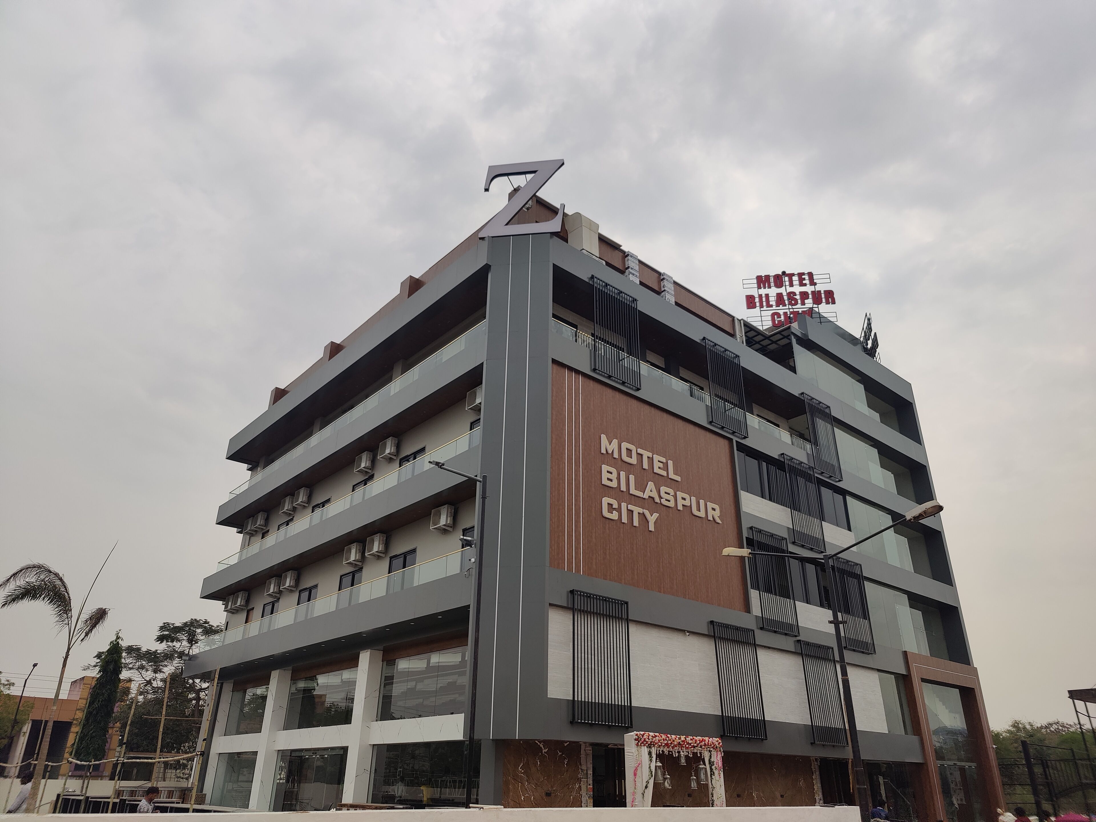 A multi-story building with a sign reading "Motel Bilaspur City".