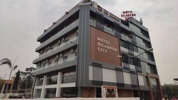 A multi-story building with a sign reading "Motel Bilaspur City".