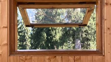 Un mur en bois avec une fenêtre rectangulaire et un interrupteur.