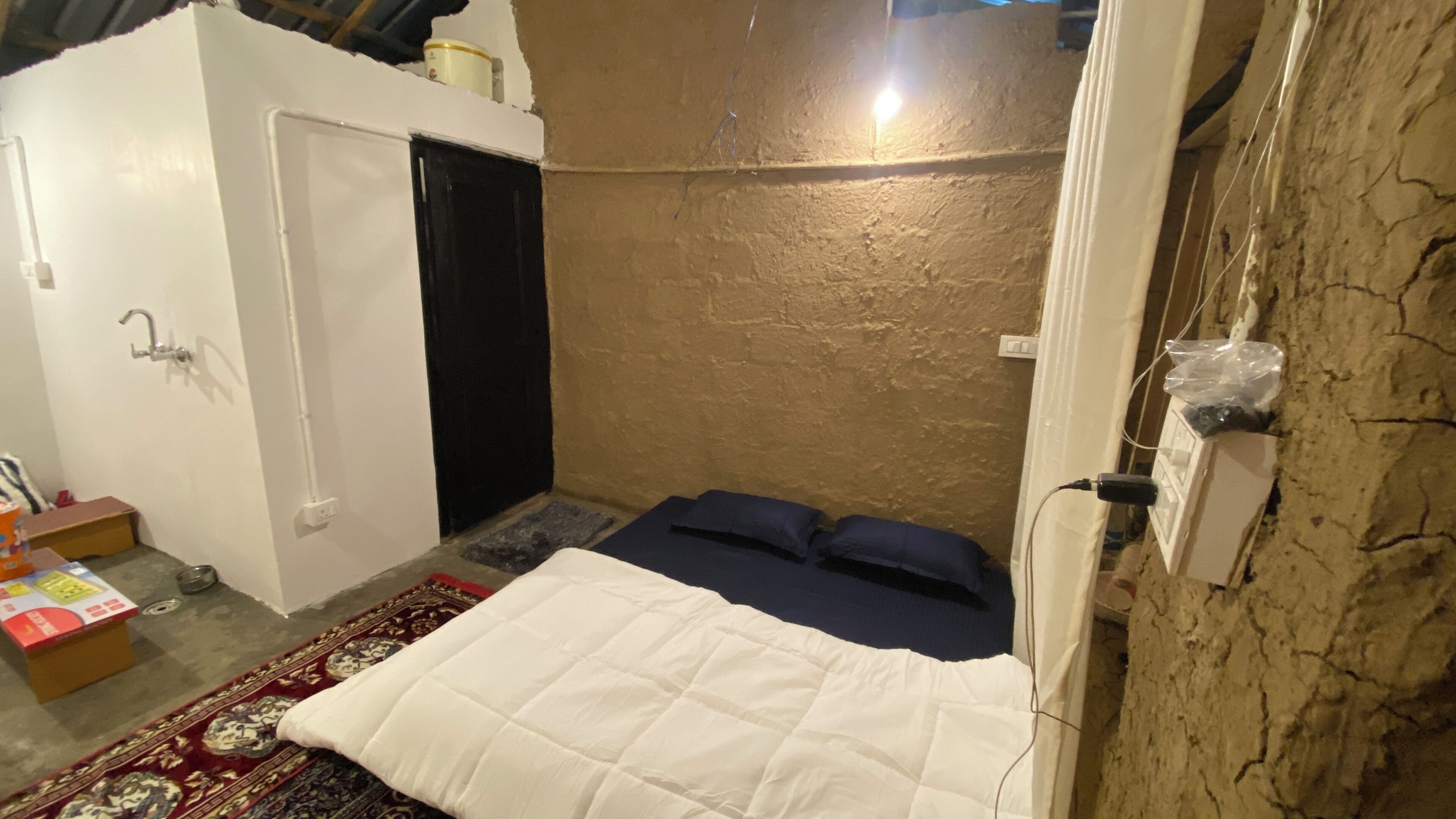 Una habitación pequeña y funcional con cama, armario y una mesita.