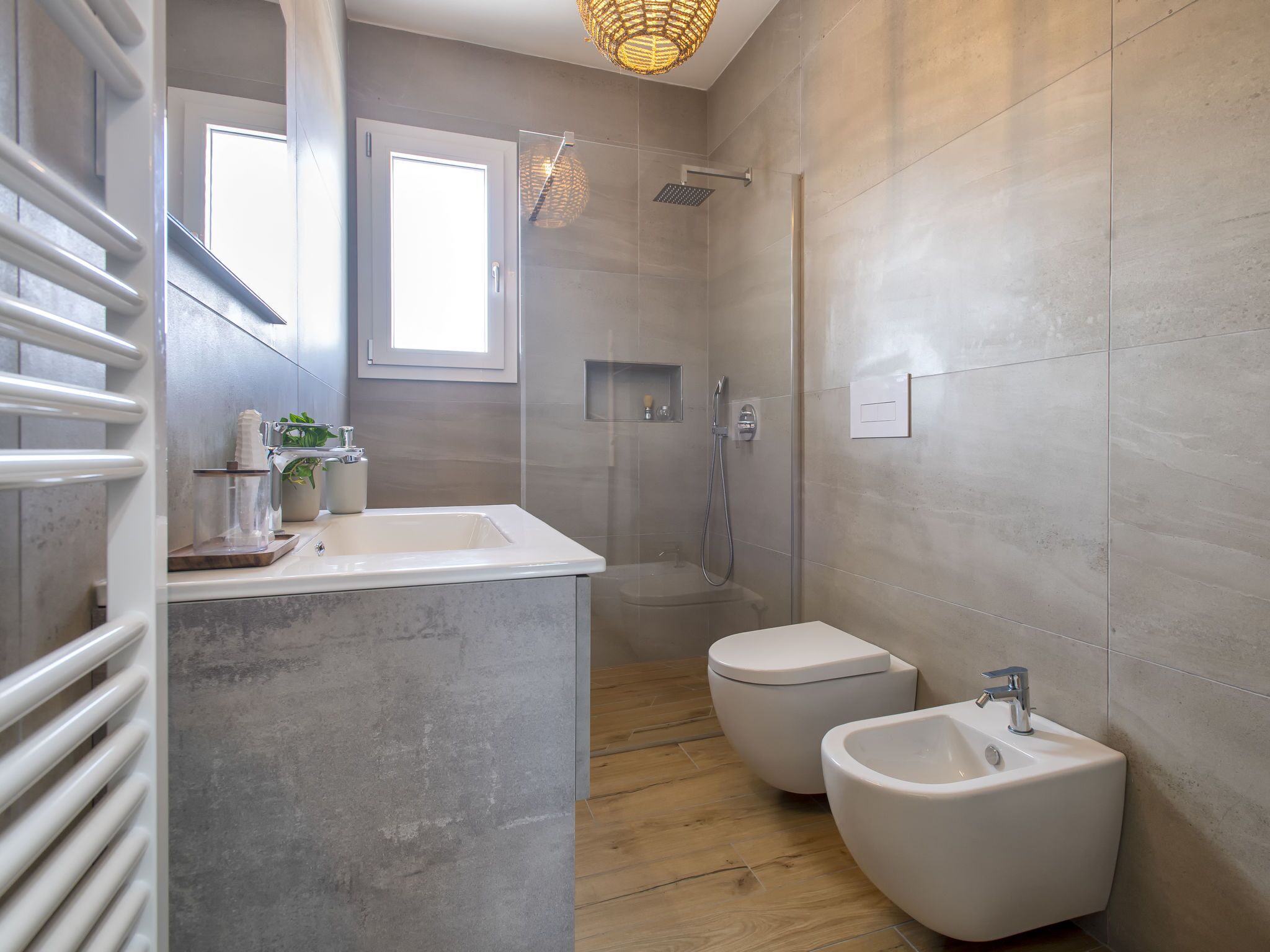 Une salle de bain moderne avec un grand miroir, une douche, des toilettes et un bidet.
