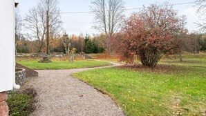 A gravel pathway leading through a park-like setting with trees and a grassy area. - Mjuamåla by Interhome (Eringsboda)