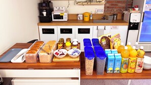 Una barra de desayuno con diversos alimentos, bebidas y recipientes.