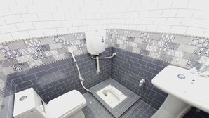 Een kleine badkamer met toilet, bidet en wastafel.