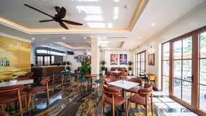 A modern restaurant with marble flooring, leather seating, and large windows offering a view of the outdoors. - Anston Castle Hotel (Phu Quoc)