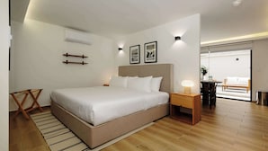 A modern bedroom with a large bed, bedside tables, a small desk, and a view of a balcony. - w* | Prestigious Loft w/ Elegant Terrace in Colima (Ciudad de México)
