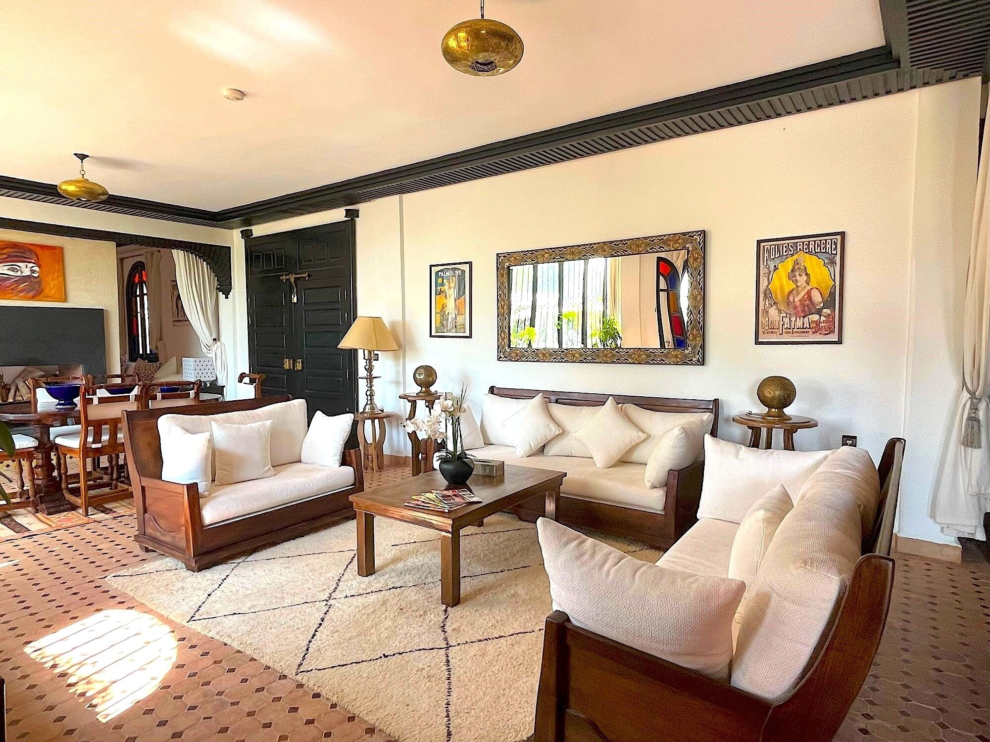 A spacious living room with a sofa set, a coffee table, and a dining area with chairs and a table.