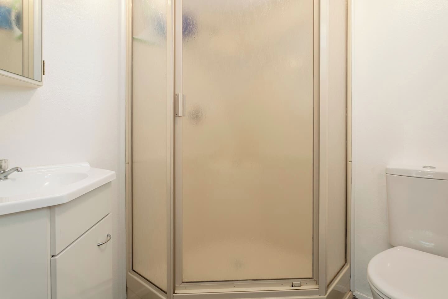 Une salle de bain avec une douche, un lavabo et des toilettes.
