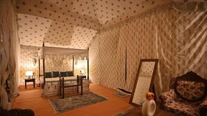 Ein gemütliches Zimmer mit Bett, Stuhl, Tisch und Spiegel.