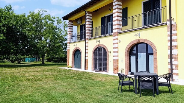 Un bâtiment jaune avec des arcades en briques et un balcon.