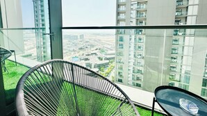 A balcony with a view of a cityscape, a chair, and a table. - Modern 2 Bed with Stunning Views (Dubai)
