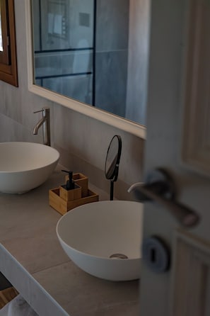 A bathroom with two sinks, a mirror, and a wooden soap dispenser. - B&B Villa Argiolas (Modena)
