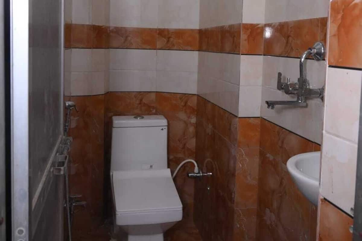 A small, compact bathroom with a toilet, a sink, and a shower.