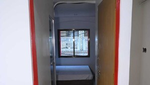 A narrow hallway with a bed, a window, and a door marked with the number 201. - VIP Paying Guest House (Varanasi)